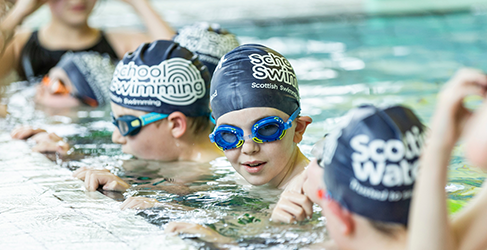 Learn to Swim School Swimming Safety Lesson young children at poolside during a Learn to Swim lesson